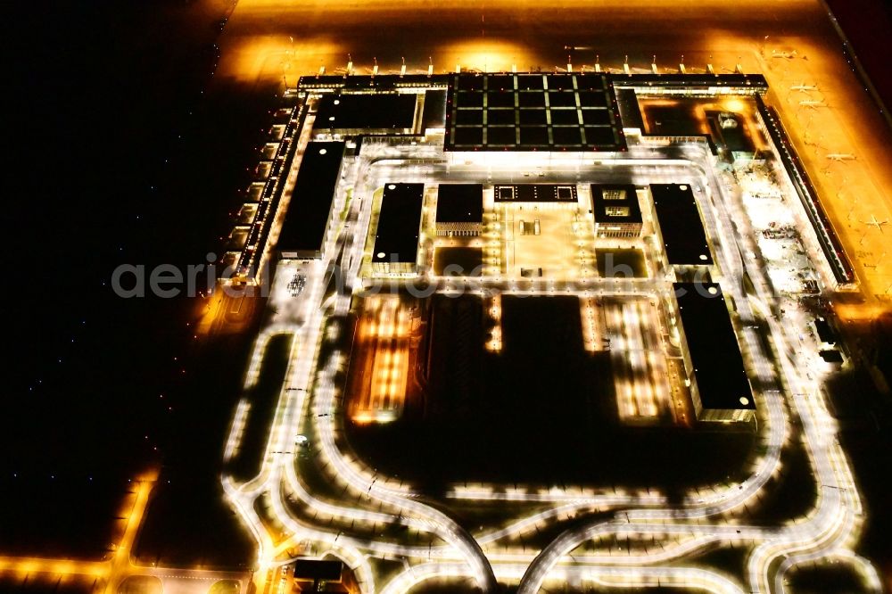 Aerial photograph at night Schönefeld - Night lighting dispatch building and terminals on the premises of the airport BER in Schoenefeld in the state Brandenburg