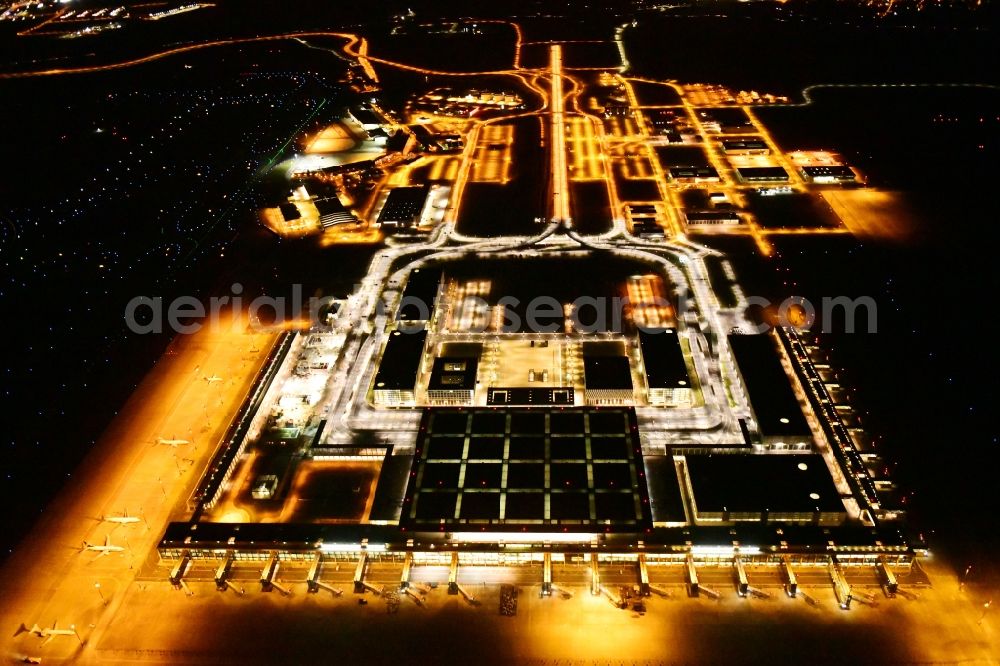 Aerial image at night Schönefeld - Night lighting dispatch building and terminals on the premises of the airport BER in Schoenefeld in the state Brandenburg