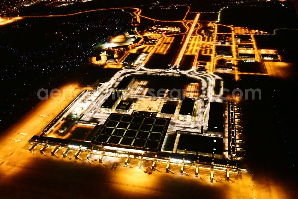 Schönefeld at night from above - Night lighting dispatch building and terminals on the premises of the airport BER in Schoenefeld in the state Brandenburg