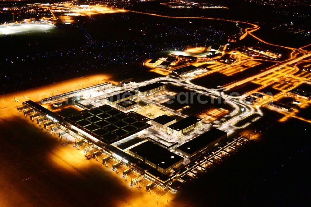 Aerial image at night Schönefeld - Night lighting dispatch building and terminals on the premises of the airport BER in Schoenefeld in the state Brandenburg