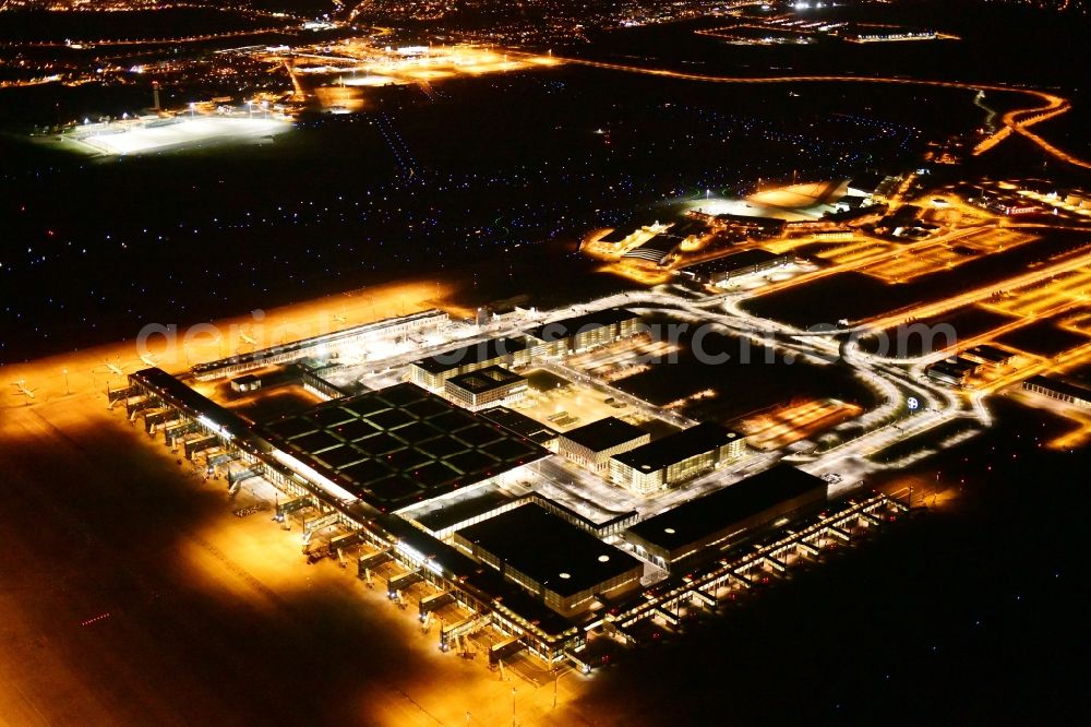 Schönefeld at night from above - Night lighting dispatch building and terminals on the premises of the airport BER in Schoenefeld in the state Brandenburg