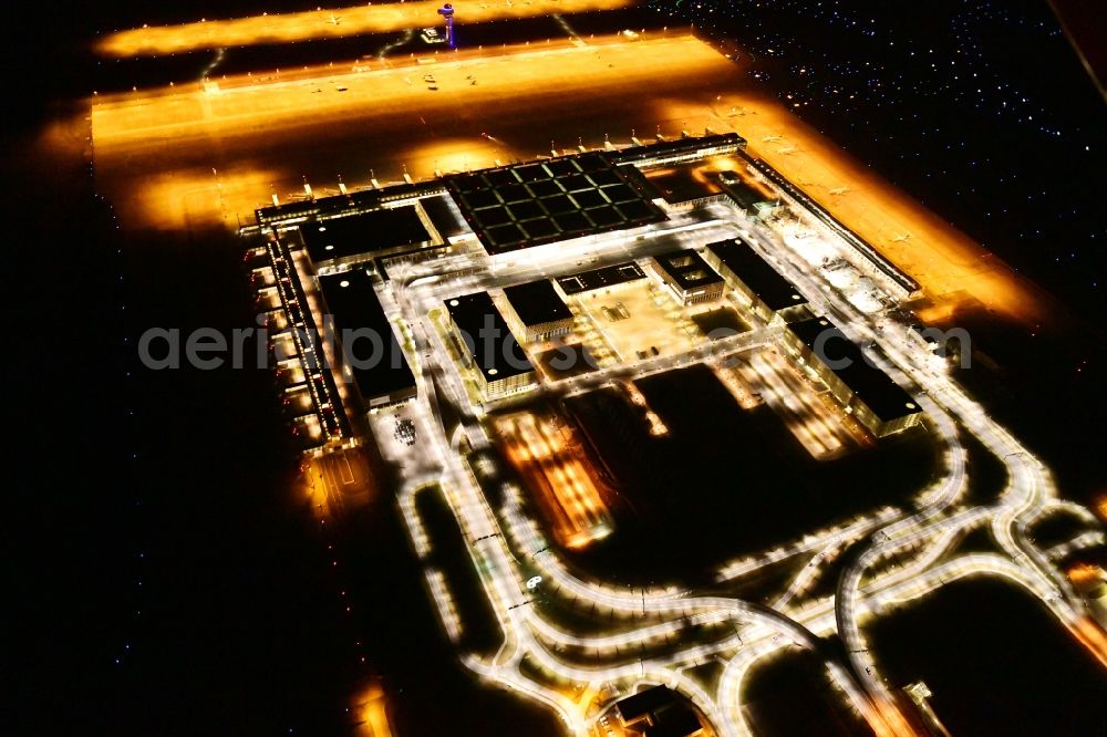 Schönefeld at night from the bird perspective: Night lighting dispatch building and terminals on the premises of the airport BER in Schoenefeld in the state Brandenburg