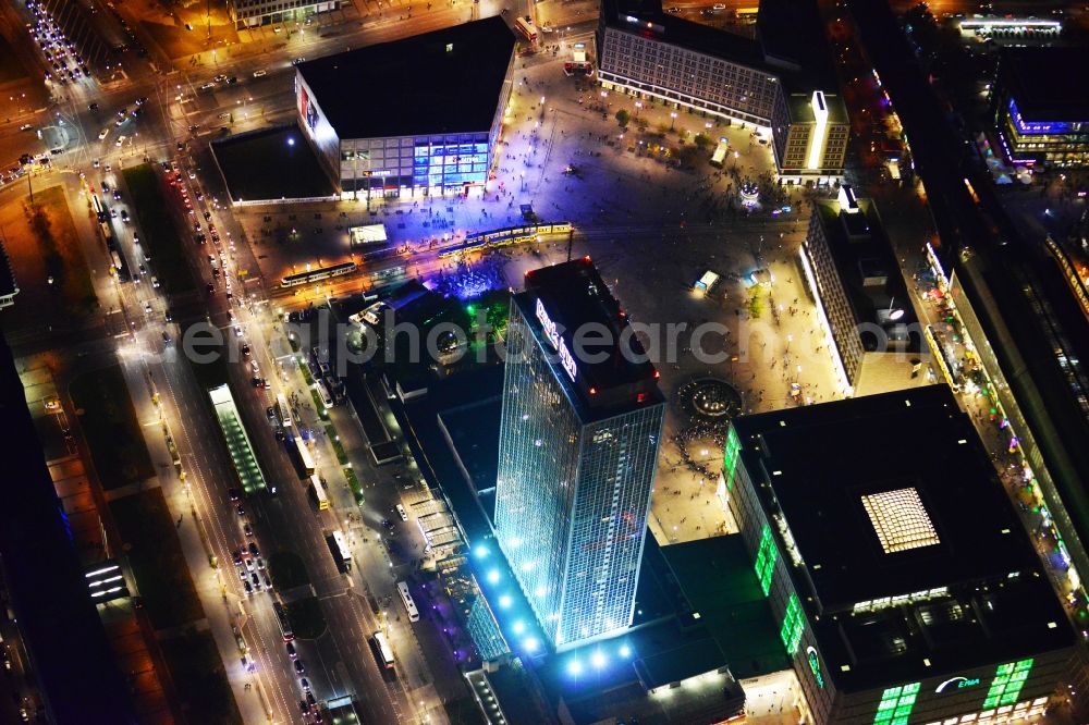 Aerial image at night Berlin - Night aerial view overlooking illuminated buildings at Alexanderplatz in the city center of Berlin. Visible among others are the department stores Saturn and Galeria Kaufhof as well as the Park Inn Hotel