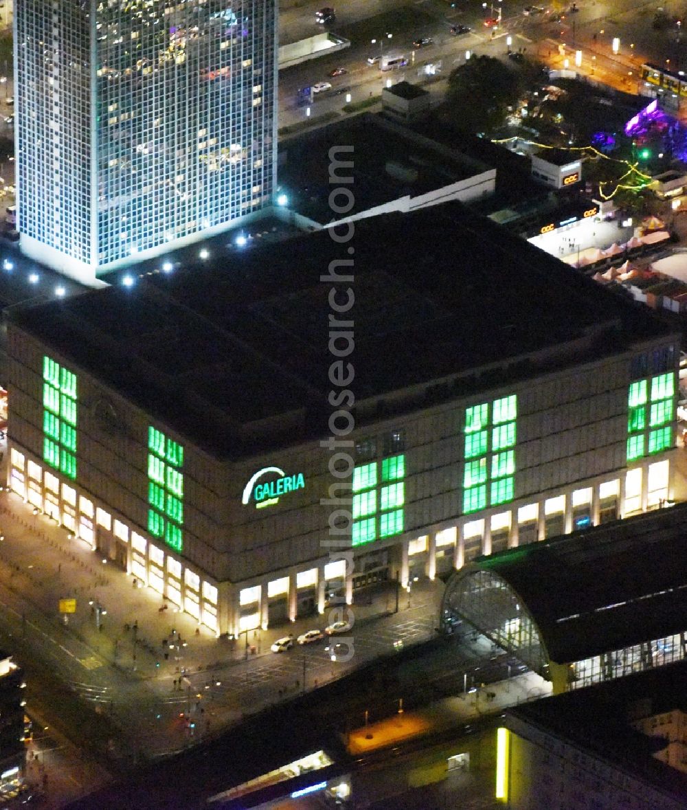 Aerial image at night Berlin - Night view overlooking illuminated buildings at Alexanderplatz in the center of Berlin. Visible among others are the shopping centre Galeria Kaufhof as well as the Park Inn Hotel