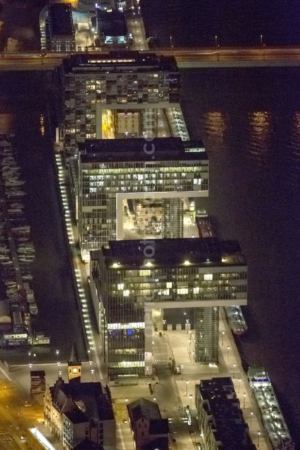 Aerial image at night Köln - Night view of new construction of houses on the crane Rheinauhafen on the banks of the Rhine in Cologne in North Rhine-Westphalia