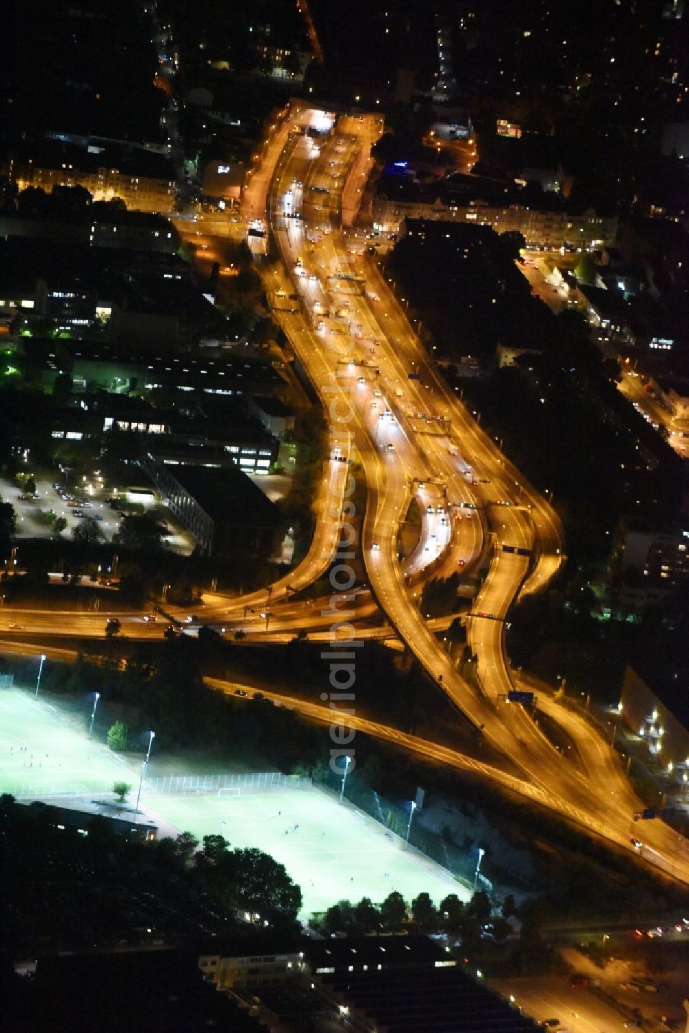 Berlin at night from the bird perspective: Night view routing and traffic lanes during the highway exit and access the motorway A 100 - 113 Grenzallee destrict Neukoelln in Berlin