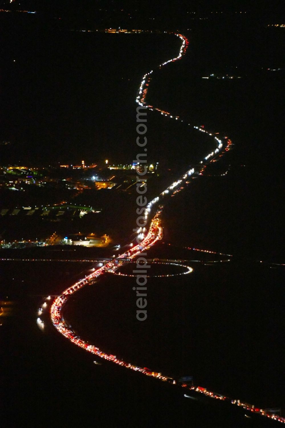 Ludwigsfelde at night from the bird perspective: Night lighting Highway congestion along the route of the lanes BAB A10 in Ludwigsfelde in the state Brandenburg, Germany