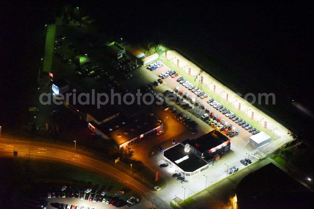 Rostock at night from the bird perspective: Night lighting Car dealership building Autoland Niederlassung Rostock on Brueckenweg in Rostock in the state Mecklenburg - Western Pomerania, Germany