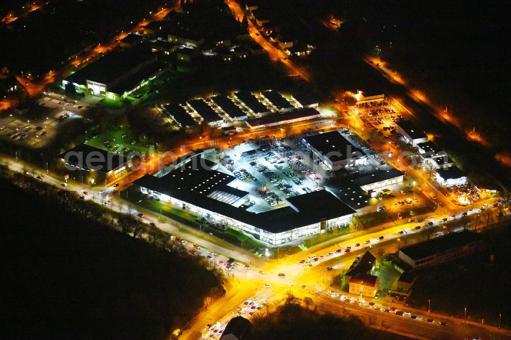 Aerial image at night Berlin - Night lighting Car dealership building BMW Niederlassung Filiale Marzahn Berlin on Blumberger Donm in the district Biesdorf in Berlin, Germany