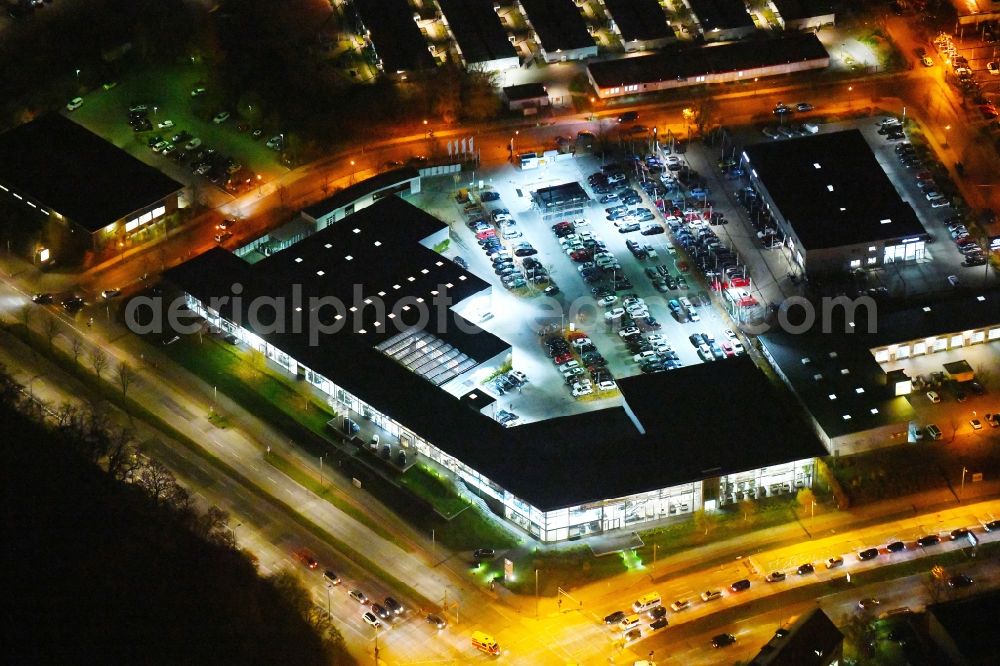 Berlin at night from the bird perspective: Night lighting Car dealership building BMW Niederlassung Filiale Marzahn Berlin on Blumberger Donm in the district Biesdorf in Berlin, Germany