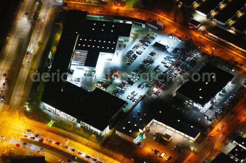 Aerial image at night Berlin - Night lighting Car dealership building BMW Niederlassung Filiale Marzahn Berlin on Blumberger Donm in the district Biesdorf in Berlin, Germany