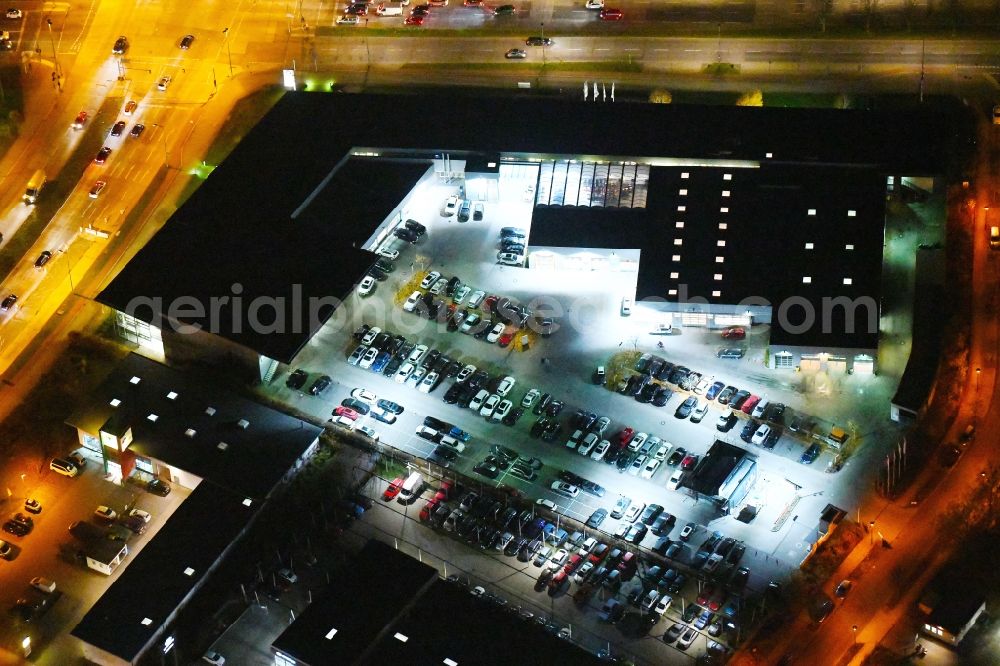 Berlin at night from the bird perspective: Night lighting Car dealership building BMW Niederlassung Filiale Marzahn Berlin on Blumberger Donm in the district Biesdorf in Berlin, Germany