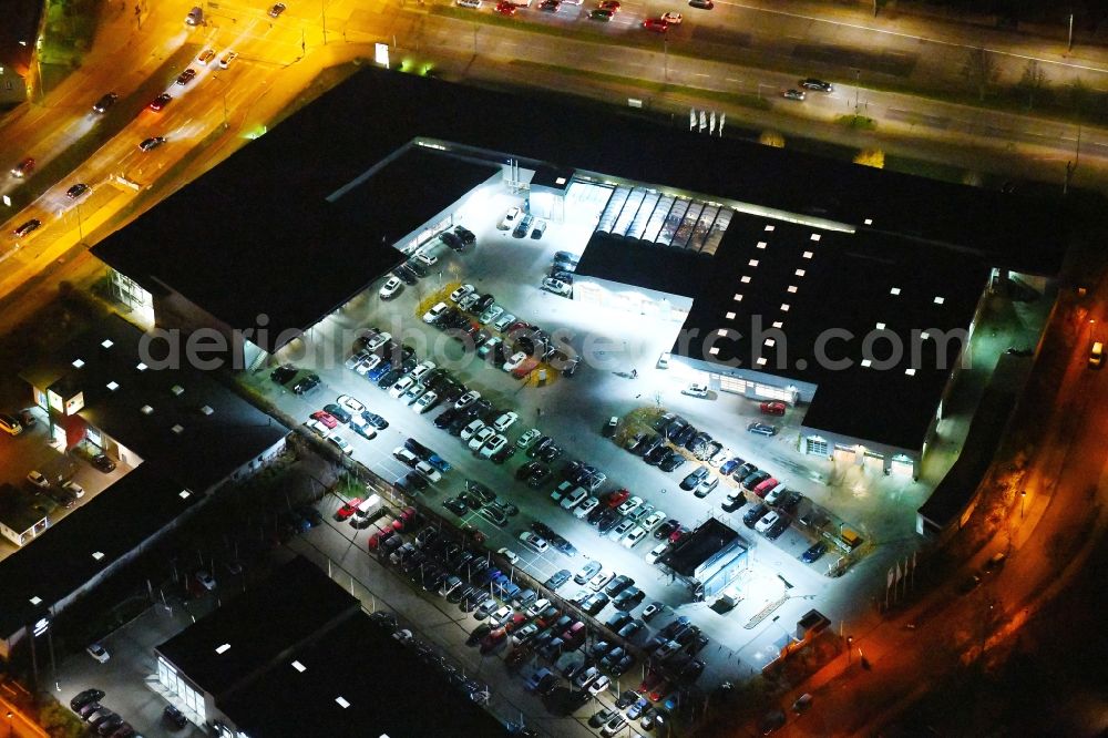 Aerial photograph at night Berlin - Night lighting Car dealership building BMW Niederlassung Filiale Marzahn Berlin on Blumberger Donm in the district Biesdorf in Berlin, Germany