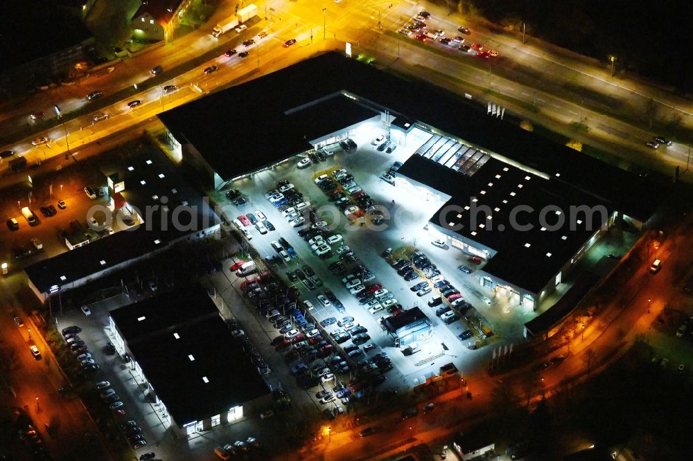 Aerial image at night Berlin - Night lighting Car dealership building BMW Niederlassung Filiale Marzahn Berlin on Blumberger Donm in the district Biesdorf in Berlin, Germany