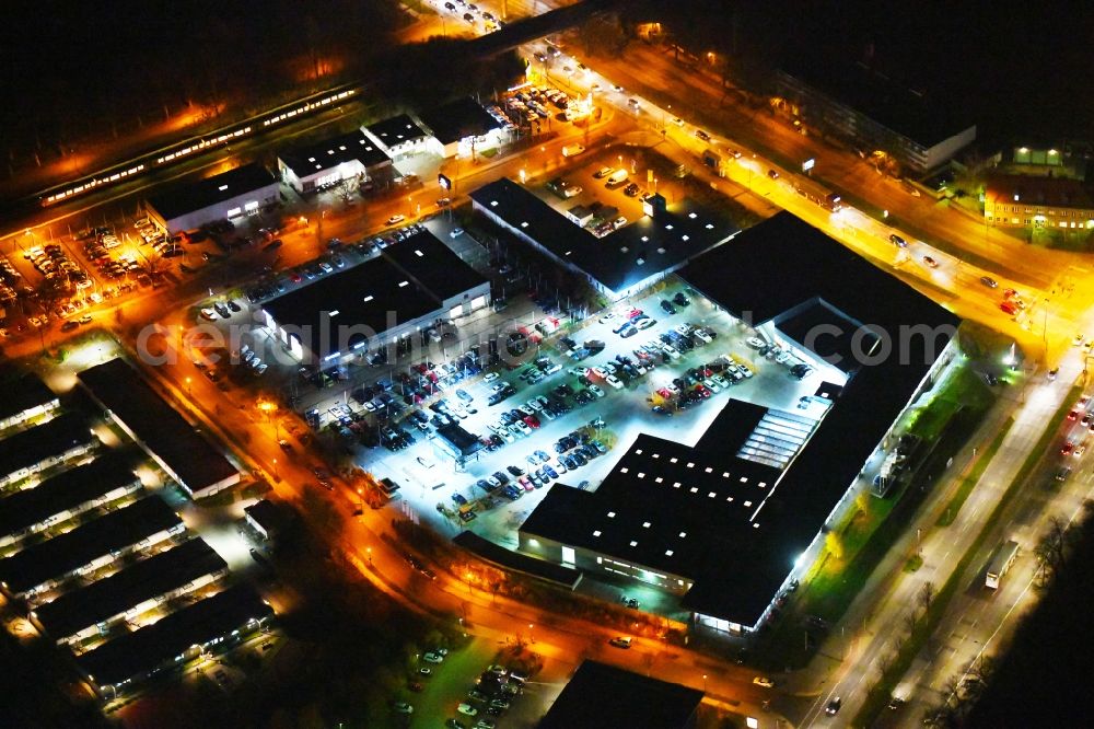 Berlin at night from the bird perspective: Night lighting Car dealership building BMW Niederlassung Filiale Marzahn Berlin on Blumberger Donm in the district Biesdorf in Berlin, Germany