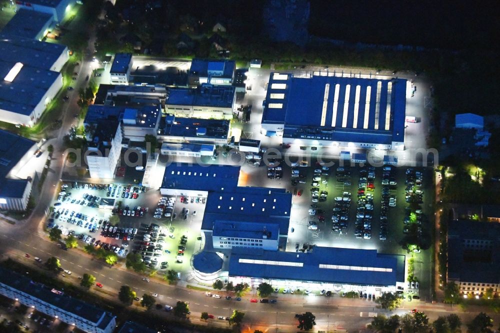 Berlin at night from the bird perspective: Night lighting car dealership building of Volkswagen Automobile Berlin GmbH on Goerzallee in the district Lichterfelde in Berlin, Germany