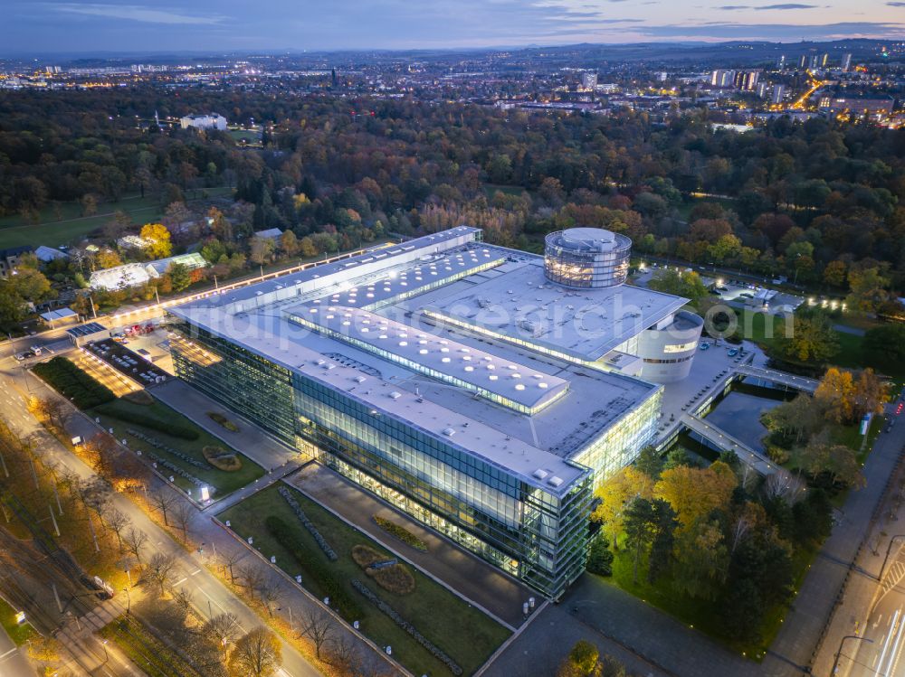 Aerial image at night Dresden - Night lighting car dealership building Glaeserne Manufaktur on street Lennestrasse in Dresden in the state Saxony, Germany