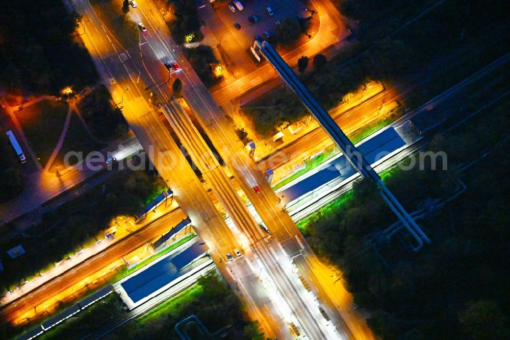 Aerial image at night Berlin - Night lighting station building and track systems of the S-Bahn station on bridge street Falkenberger Chaussee in the district Hohenschoenhausen in Berlin, Germany