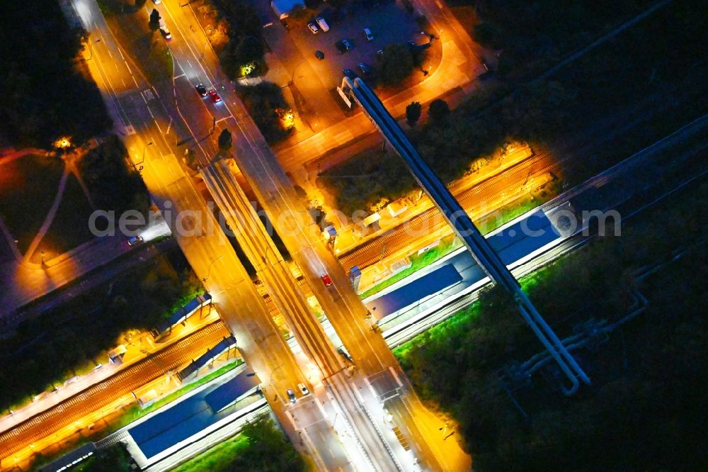 Berlin at night from the bird perspective: Night lighting station building and track systems of the S-Bahn station on bridge street Falkenberger Chaussee in the district Hohenschoenhausen in Berlin, Germany