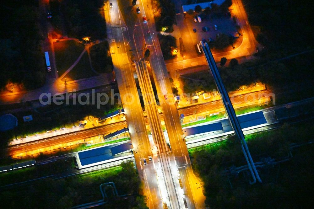 Aerial photograph at night Berlin - Night lighting station building and track systems of the S-Bahn station on bridge street Falkenberger Chaussee in the district Hohenschoenhausen in Berlin, Germany