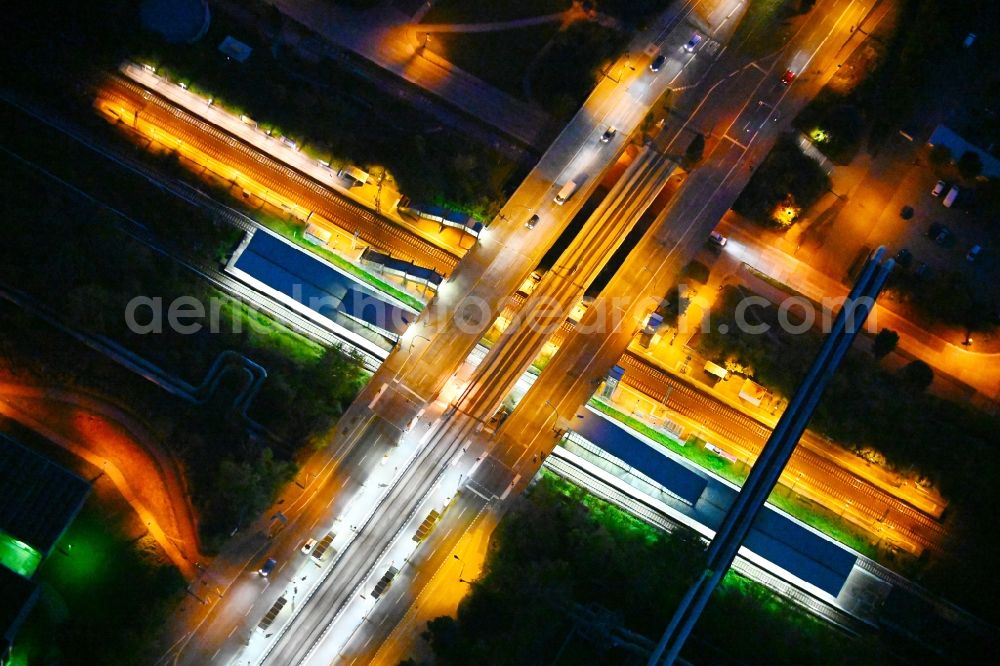 Berlin at night from the bird perspective: Night lighting station building and track systems of the S-Bahn station on bridge street Falkenberger Chaussee in the district Hohenschoenhausen in Berlin, Germany