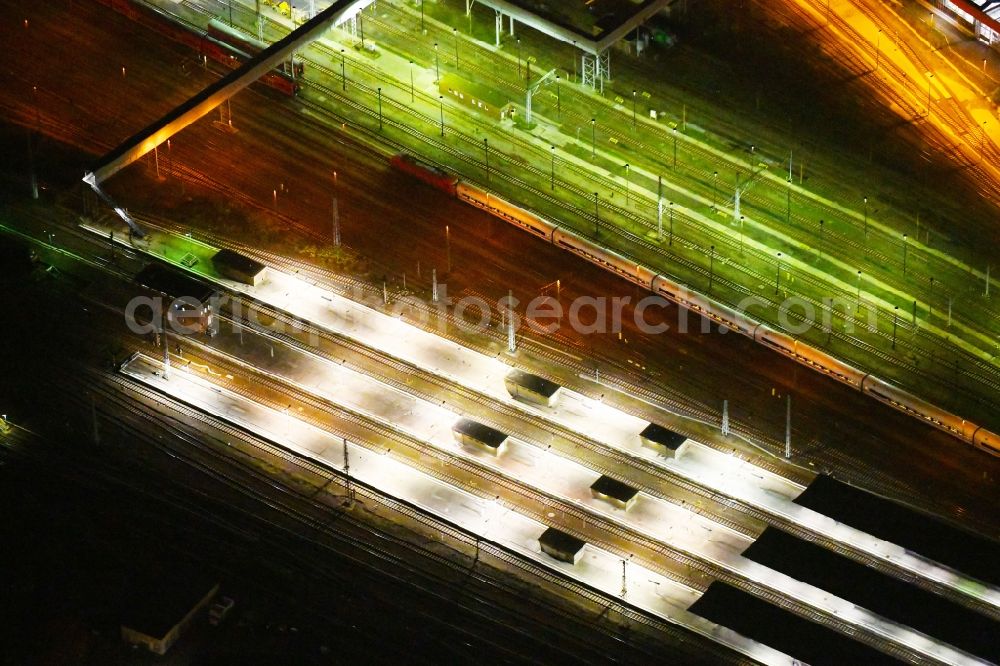 Aerial image at night Berlin - Night lighting Station building and track systems of the S-Bahn station Berlin - Lichtenberg in the district Lichtenberg in Berlin, Germany