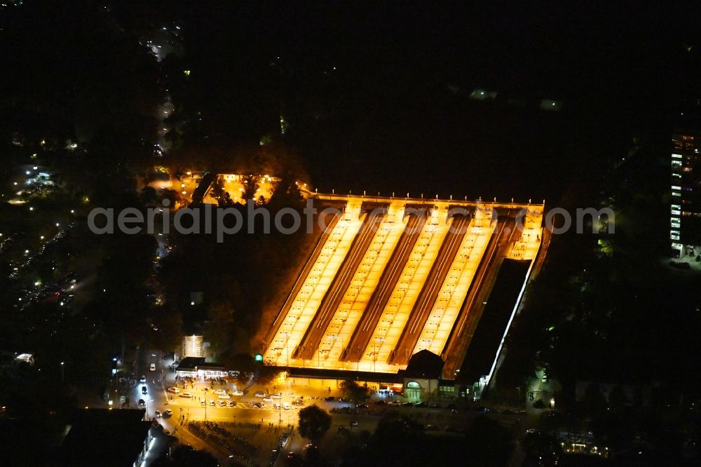 Aerial image at night Berlin - Night lighting Station building and track systems of the S-Bahn station on Flatowallee in the district Charlottenburg in Berlin, Germany