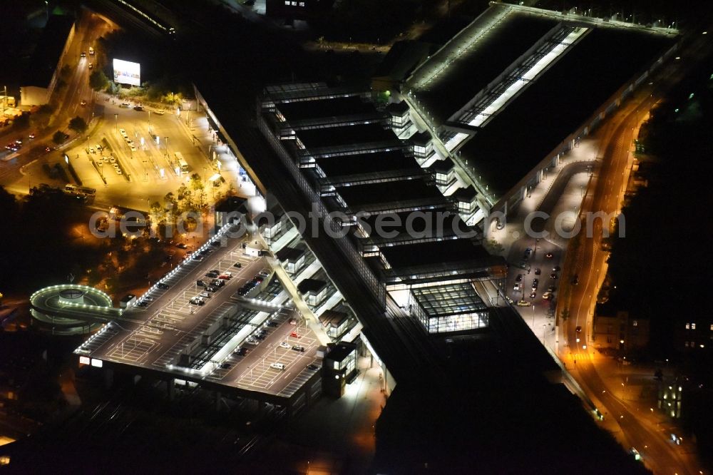 Aerial image at night Berlin - Night view station building and track systems of the S-Bahn station Suedkreuz in Berlin