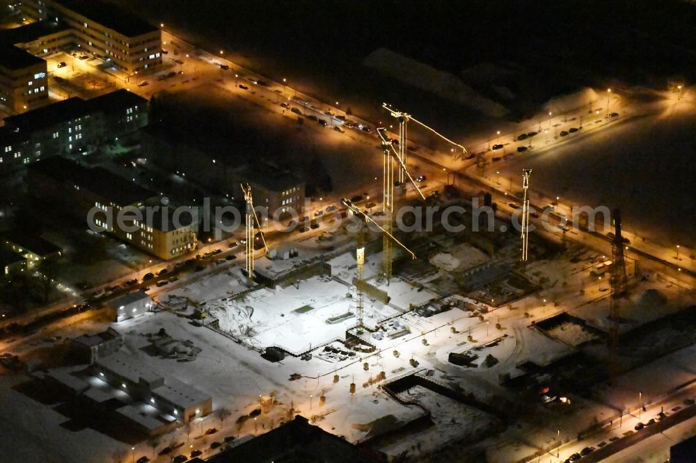 Aerial image at night Berlin - Night view of wintry snowy Construction site to build a new office and commercial building Allianz Campus Berlin in the district Bezirk Treptow-Koepenick in Berlin