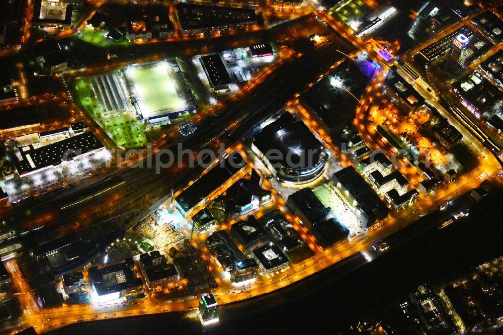 Aerial photograph at night Berlin - Night lighting Construction site for the new building eines Kino- Freizeit- and Hotelkomplexes on Anschutz- Areal along of Muehlenstrasse in the district Bezirk Friedrichshain-Kreuzberg in Berlin, Germany