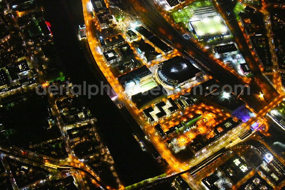 Aerial photograph at night Berlin - Night lighting Construction site for the new building eines Kino- Freizeit- and Hotelkomplexes on Anschutz- Areal along of Muehlenstrasse in the district Bezirk Friedrichshain-Kreuzberg in Berlin, Germany