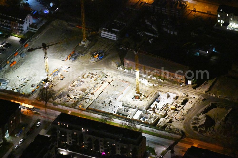 Berlin at night from the bird perspective: Night lighting Construction site to build a new multi-family residential complex of Gut Alt-Biesdorf on Weissenhoeher Strasse in Berlin, Germany