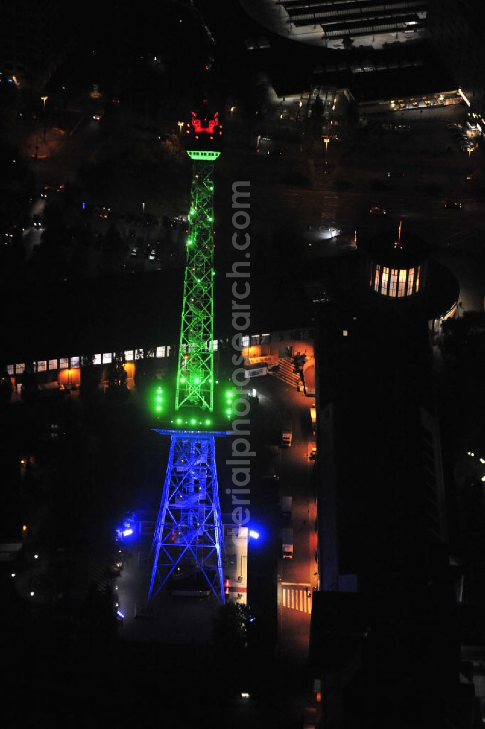 Berlin at night from the bird perspective: Nachtaufnahme: Sicht auf das beleuchtete Messegelände mit dem Funkturm anlässlich des Festival Of Lights 2010 in Berlin. Nightshot: View to the illuminated exhibition ground with the Radio Tower Berlin in celebration of the Festival Of Lights 2010.