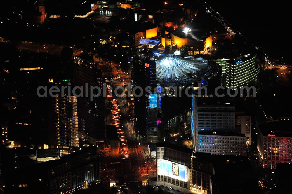 Berlin at night from the bird perspective: Nachtluftbild vom nächtlichen Berlin anläßlich des Festival of Lights in der Berliner Innenstadt. Hunderttausende Besucher strömten am letzten Wochenende des Festivals zu den illuminierten Gebäuden und angestrahlten Bereichen der Innenstadt. Blick auf den Leipziger Platz und die Potsdamer Straße über das Gebiet Potsdamer Platz den Berliner Stadtteilen Mitte und Tiergarten. Im Vordergrund ist der Deutsche-Bahn-Tower und der Kollhoff-Tower, im Hintergrund das Sony-Center und die Berliner Philharmonie. Night shot of Berlin's illuminated inner-city; here the square Leipziger Platz with view to the street Potsdamer Strasse in the area Potsdamer Platz. In the foreground the Deutsche-Bahn-Tower and the Kollhoff-Tower, behind it the Sony-Center and the Philharmonie.