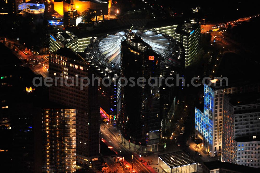 Aerial image at night Berlin - Nachtluftbild vom nächtlichen Berlin anläßlich des Festival of Lights in der Berliner Innenstadt. Hunderttausende Besucher strömten am letzten Wochenende des Festivals zu den illuminierten Gebäuden und angestrahlten Bereichen der Innenstadt. Blick auf den Leipziger Platz und die Potsdamer Straße über das Gebiet Potsdamer Platz den Berliner Stadtteilen Mitte und Tiergarten. Im Vordergrund ist der Deutsche-Bahn-Tower und der Kollhoff-Tower, im Hintergrund das Sony-Center und die Berliner Philharmonie. Night shot of Berlin's illuminated inner-city; here the square Leipziger Platz with view to the street Potsdamer Strasse in the area Potsdamer Platz. In the foreground the Deutsche-Bahn-Tower and the Kollhoff-Tower, behind it the Sony-Center and the Philharmonie.