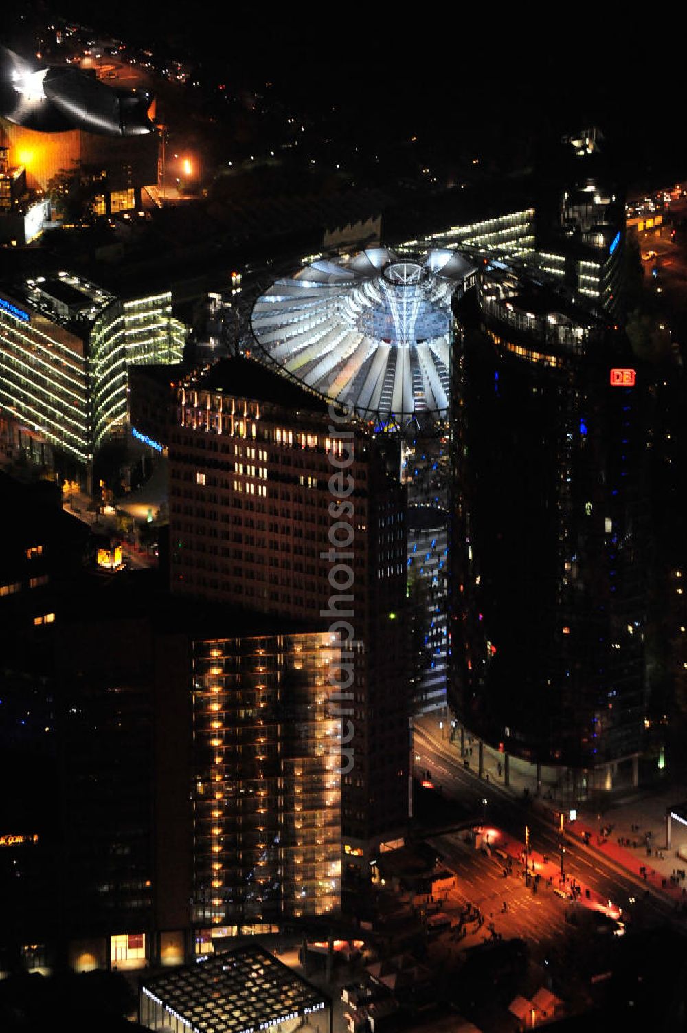 Berlin at night from above - Nachtluftbild vom nächtlichen Berlin anläßlich des Festival of Lights in der Berliner Innenstadt. Hunderttausende Besucher strömten am letzten Wochenende des Festivals zu den illuminierten Gebäuden und angestrahlten Bereichen der Innenstadt. Blick auf die Bellevuestraße und Potsdamer Straße vom Potsdamer Platz aus im Berliner Stadtteil Tiergarten. Im Vordergrund ist der Deutsche-Bahn-Tower und der Kollhoff-Tower, im Hintergrund das Sony-Center. Night shot of Berlin's illuminated inner-city; here the square Potsdamer Platz and the streets Potsdamer Strasse and Bellevuestrasse, in the foreground the Deutsche-Bahn-Tower and the Kollhoff-Tower, behind it the Sony-Center.