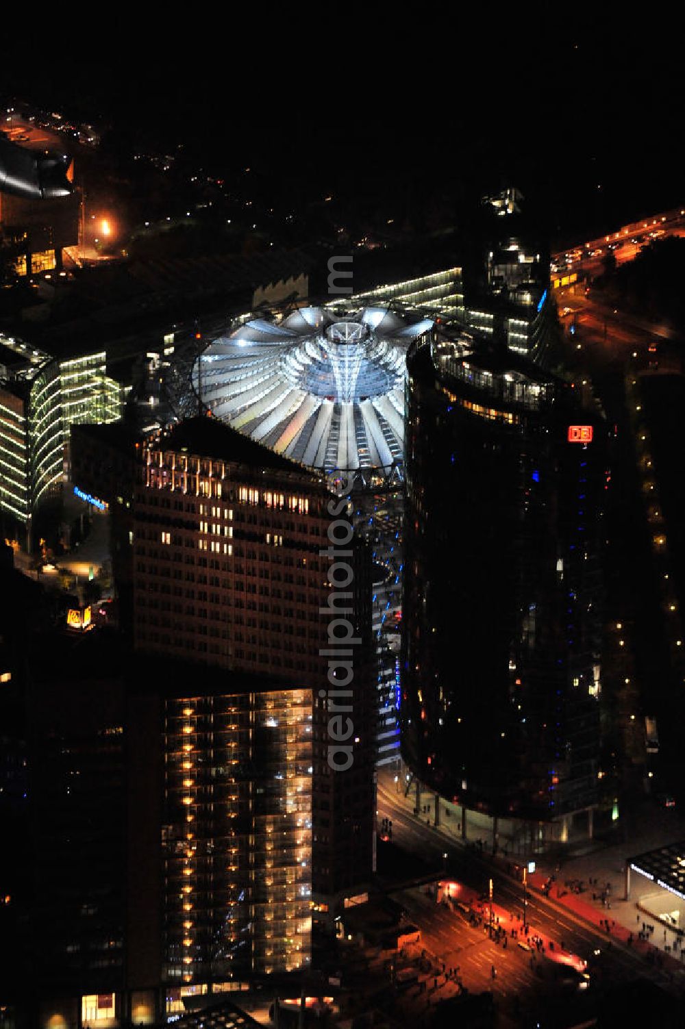 Berlin at night from the bird perspective: Nachtluftbild vom nächtlichen Berlin anläßlich des Festival of Lights in der Berliner Innenstadt. Hunderttausende Besucher strömten am letzten Wochenende des Festivals zu den illuminierten Gebäuden und angestrahlten Bereichen der Innenstadt. Blick auf die Bellevuestraße und Potsdamer Straße vom Potsdamer Platz aus im Berliner Stadtteil Tiergarten. Im Vordergrund ist der Deutsche-Bahn-Tower und der Kollhoff-Tower, im Hintergrund das Sony-Center. Night shot of Berlin's illuminated inner-city; here the square Potsdamer Platz and the streets Potsdamer Strasse and Bellevuestrasse, in the foreground the Deutsche-Bahn-Tower and the Kollhoff-Tower, behind it the Sony-Center.