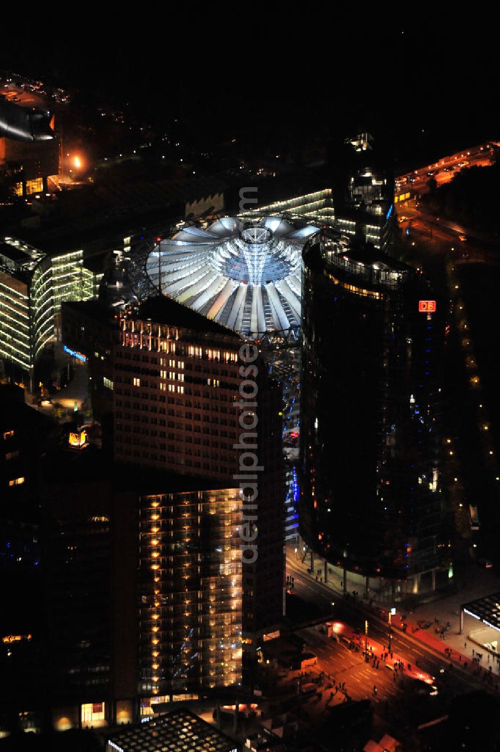 Aerial photograph at night Berlin - Nachtluftbild vom nächtlichen Berlin anläßlich des Festival of Lights in der Berliner Innenstadt. Hunderttausende Besucher strömten am letzten Wochenende des Festivals zu den illuminierten Gebäuden und angestrahlten Bereichen der Innenstadt. Blick auf die Bellevuestraße und Potsdamer Straße vom Potsdamer Platz aus im Berliner Stadtteil Tiergarten. Im Vordergrund ist der Deutsche-Bahn-Tower und der Kollhoff-Tower, im Hintergrund das Sony-Center. Night shot of Berlin's illuminated inner-city; here the square Potsdamer Platz and the streets Potsdamer Strasse and Bellevuestrasse, in the foreground the Deutsche-Bahn-Tower and the Kollhoff-Tower, behind it the Sony-Center.