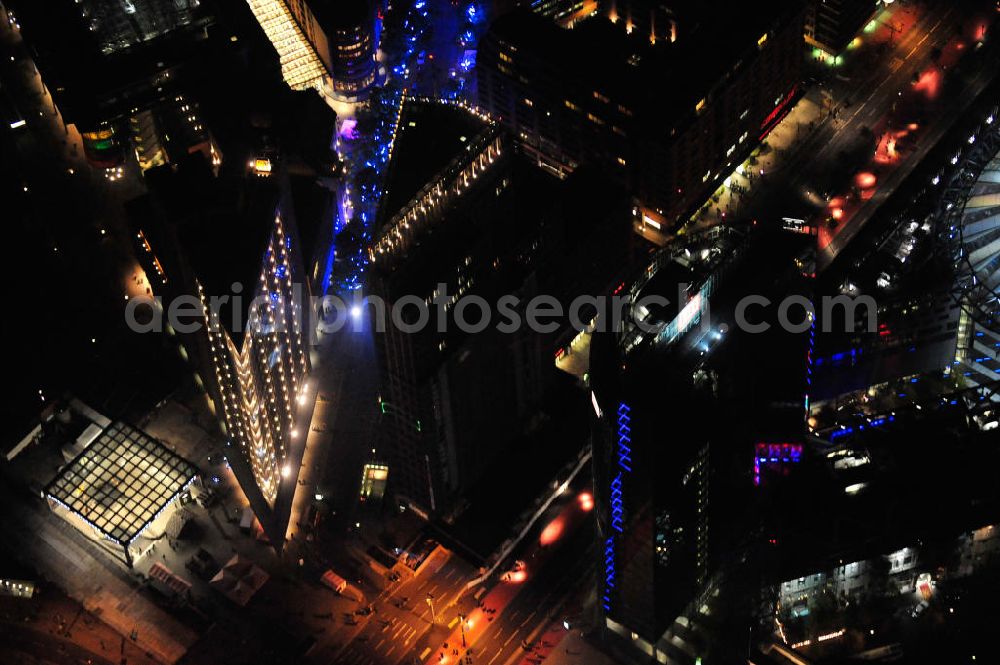 Berlin at night from above - Nachtluftbild vom nächtlichen Berlin anläßlich des Festival of Lights in der Berliner Innenstadt. Hunderttausende Besucher strömten am letzten Wochenende des Festivals zu den illuminierten Gebäuden und angestrahlten Bereichen der Innenstadt. Blick auf die Potsdamer Straße im Berliner Stadtteil Tiergarten sowie ein Eingang zum unterirdischen Bahnhof Potsdamer Platz. Im Vordergrund sind der Deutsche-Bahn-Tower und der Kollhoff-Tower zu sehen. Night shot of Berlin's illuminated inner-city. View onto the street Potsdamer Strasse, in the foreground the Deutsche-Bahn-Tower, the Kollhoff-Tower and an entrance to the underground train station Potsdamer Platz.