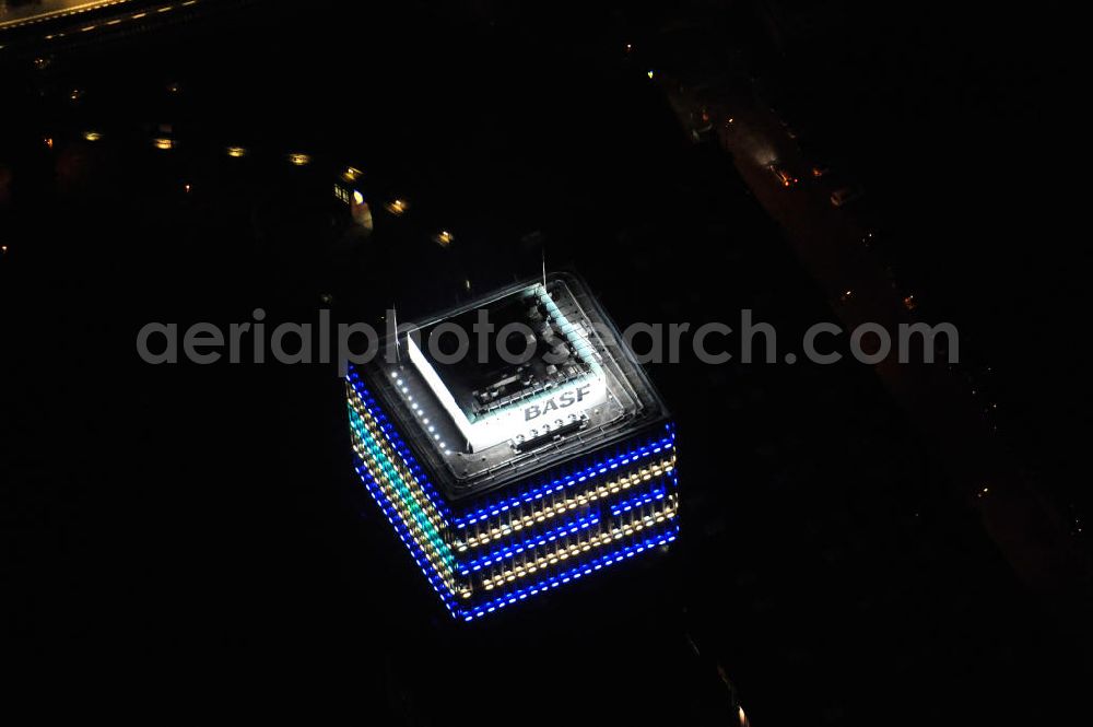 Berlin at night from the bird perspective: Nachtaufnahme: Oberbaum-City, das Gelände der ehemaligen Narva Lampenfabrik, in Berlin-Friedrichshain zwischen U-Bahnhof und S-Bahnhof Warschauer Straße. Das markanteste Bauwerk ist der Narva-Turm, das erste Hochhaus von Berlin, daneben die U-Bahn-Abstellanlage entlang der Rudolfstraße. Night Shot: Oberbaum City in Berlin-Friedrichshain with the Narva-Tower, the first tower building of Berlin. Next to it the storage siding of Berlin subway along the street Rudolfstrasse.