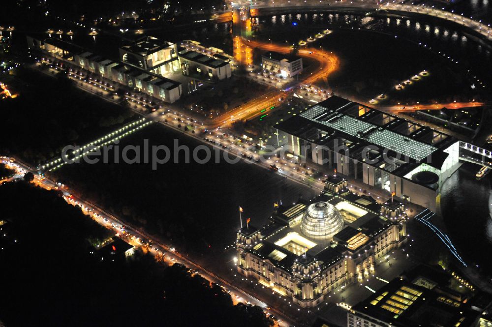 Aerial image at night Berlin - Night lighting building of the Parliament of the German Parliament - Berlin Reichstag and the Paul Loebe Building on Republic Square at the Spreebogen in Berlin - Mitte