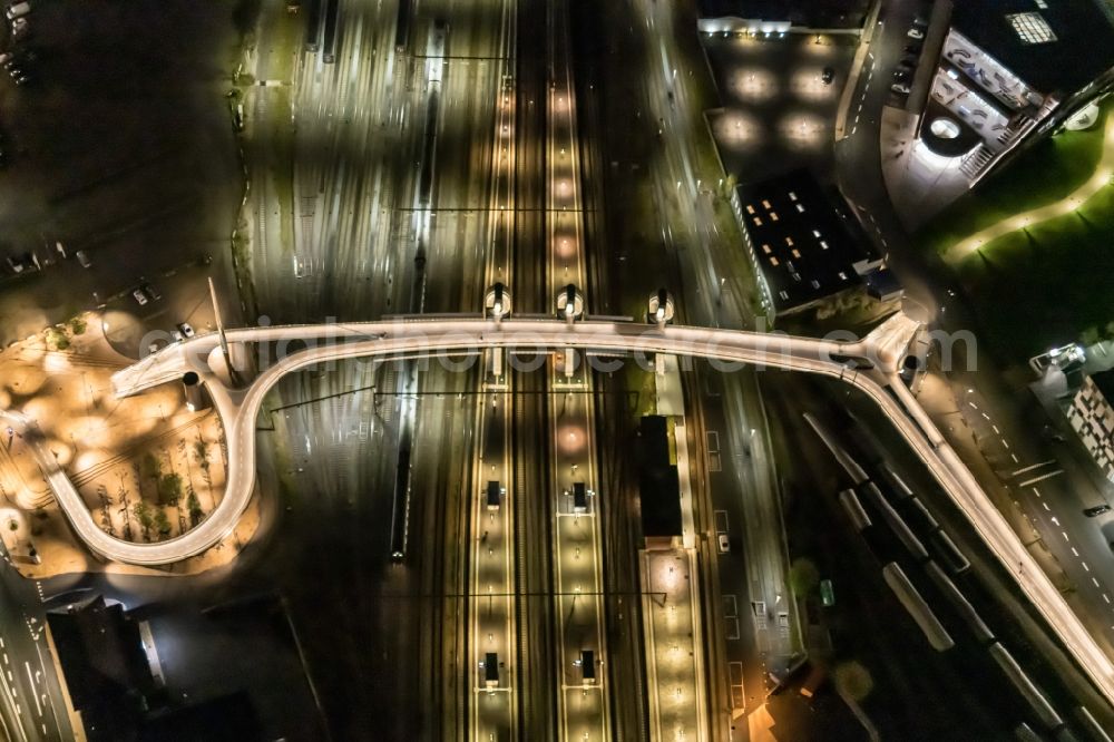 Aerial photograph at night Odense - Night lighting bridge and track progress and building of the main station of the railway in Odense in Syddanmark, Denmark