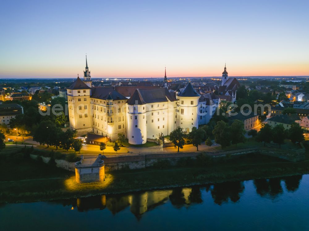 Torgau at night from the bird perspective: Night lighting castle of the fortress Schloss und Schlosskirche Hartenfels in Torgau in the state Saxony