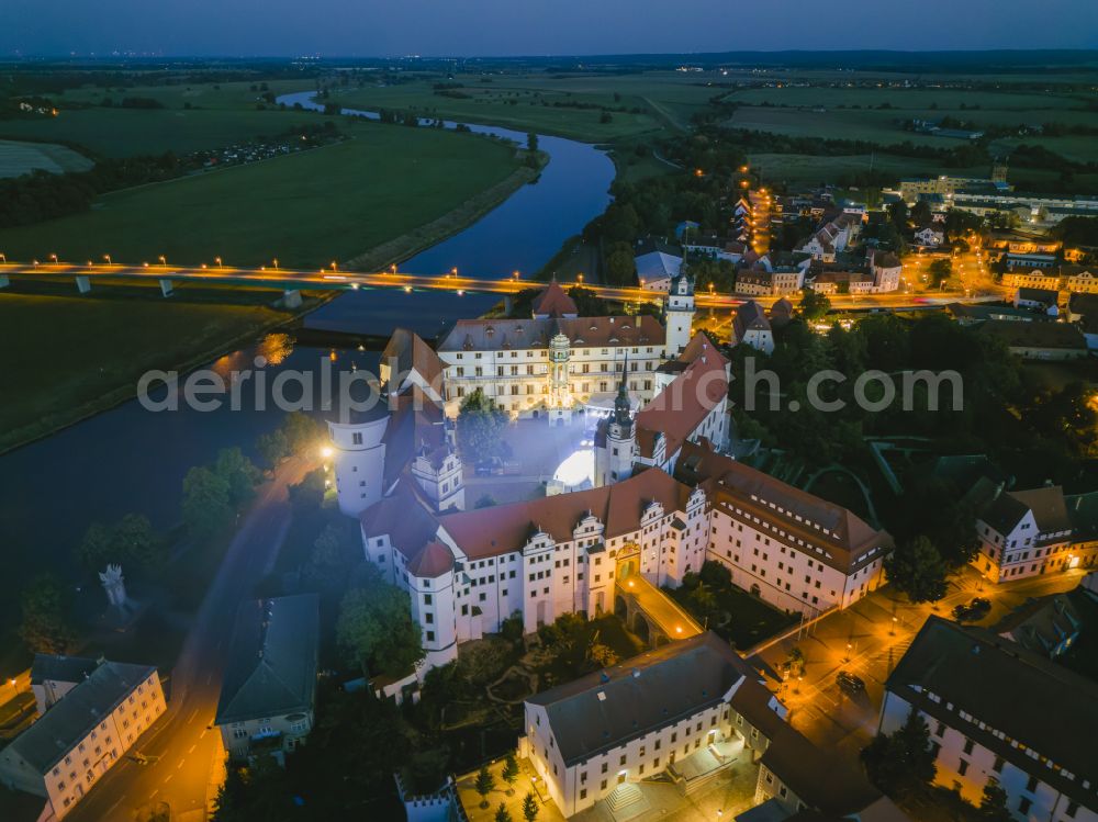 Aerial image at night Torgau - Night lighting castle of the fortress Schloss und Schlosskirche Hartenfels in Torgau in the state Saxony