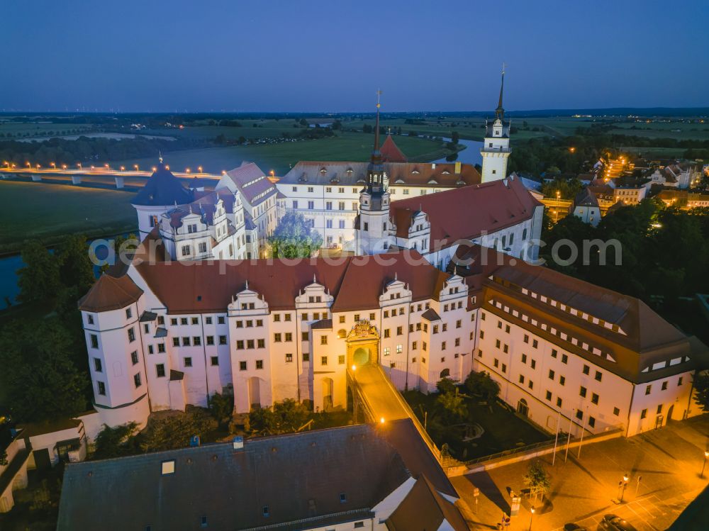 Torgau at night from the bird perspective: Night lighting castle of the fortress Schloss und Schlosskirche Hartenfels in Torgau in the state Saxony