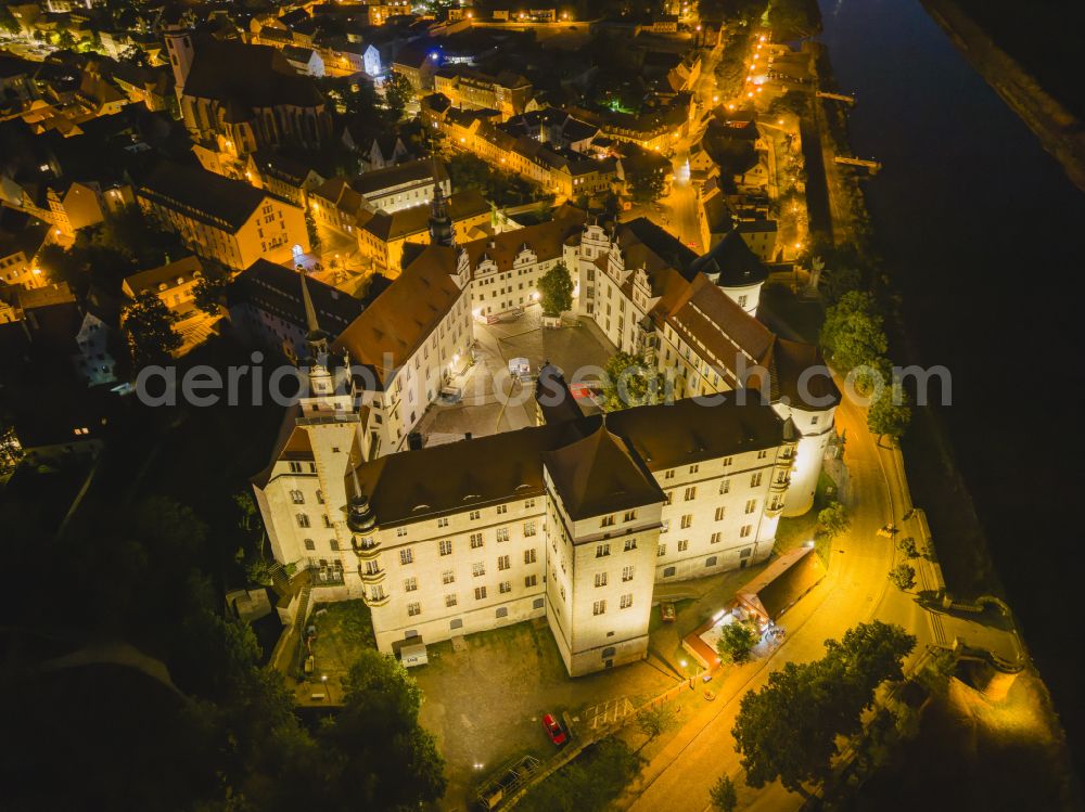 Aerial photograph at night Torgau - Night lighting castle of the fortress Schloss und Schlosskirche Hartenfels in Torgau in the state Saxony