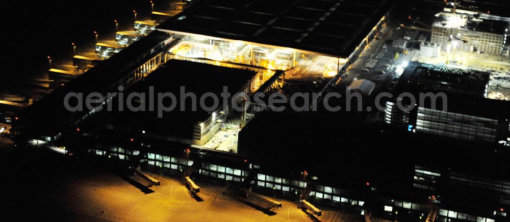 Schönefeld at night from the bird perspective: Nachtluftbild der Baustelle des neuen Terminals am Flughafen Berlin - Schönefeld. Der neue Terminal wird südlich des bisherigen Flughafens Berlin- Schönefeld errichtet. Ausführende Firmen: Hochtief AG; EUROVIA Beton; PORR; BERGER Bau; Karl Weiss; Matthai; Schäler Bau Berlin GmbH; STRABAG; Night Shot of Construction area of the new terminal at Schönefeld Airport (BBI). The new terminal is in the south of the airport Berlin -Schoenefeld quality built. Exporting companies: Hochtief AG; EUROVIA Beton; PORR; BERGER Bau; Karl Weiss; Matthai; Schäler Bau Berlin GmbH; STRABAG;