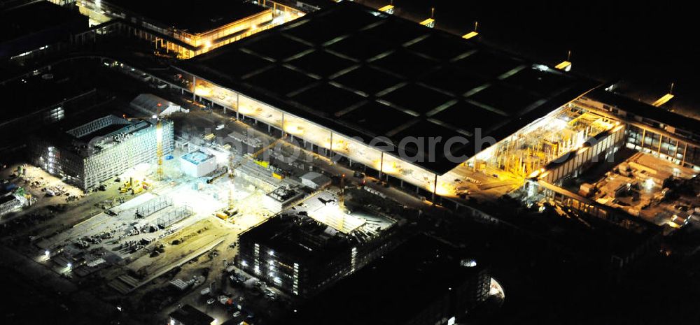 Schönefeld at night from the bird perspective: Nachtluftbild der Baustelle des neuen Terminals am Flughafen Berlin - Schönefeld. Der neue Terminal wird südlich des bisherigen Flughafens Berlin- Schönefeld errichtet. Ausführende Firmen: Hochtief AG; EUROVIA Beton; PORR; BERGER Bau; Karl Weiss; Matthai; Schäler Bau Berlin GmbH; STRABAG; Night Shot of Construction area of the new terminal at Schönefeld Airport (BBI). The new terminal is in the south of the airport Berlin -Schoenefeld quality built. Exporting companies: Hochtief AG; EUROVIA Beton; PORR; BERGER Bau; Karl Weiss; Matthai; Schäler Bau Berlin GmbH; STRABAG;