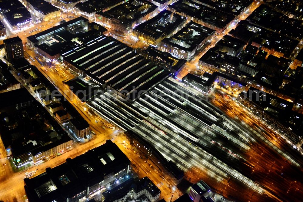 München at night from the bird perspective: Night aerial view of the tracks and rails at the train station building of the main station of Munich in Bavaria