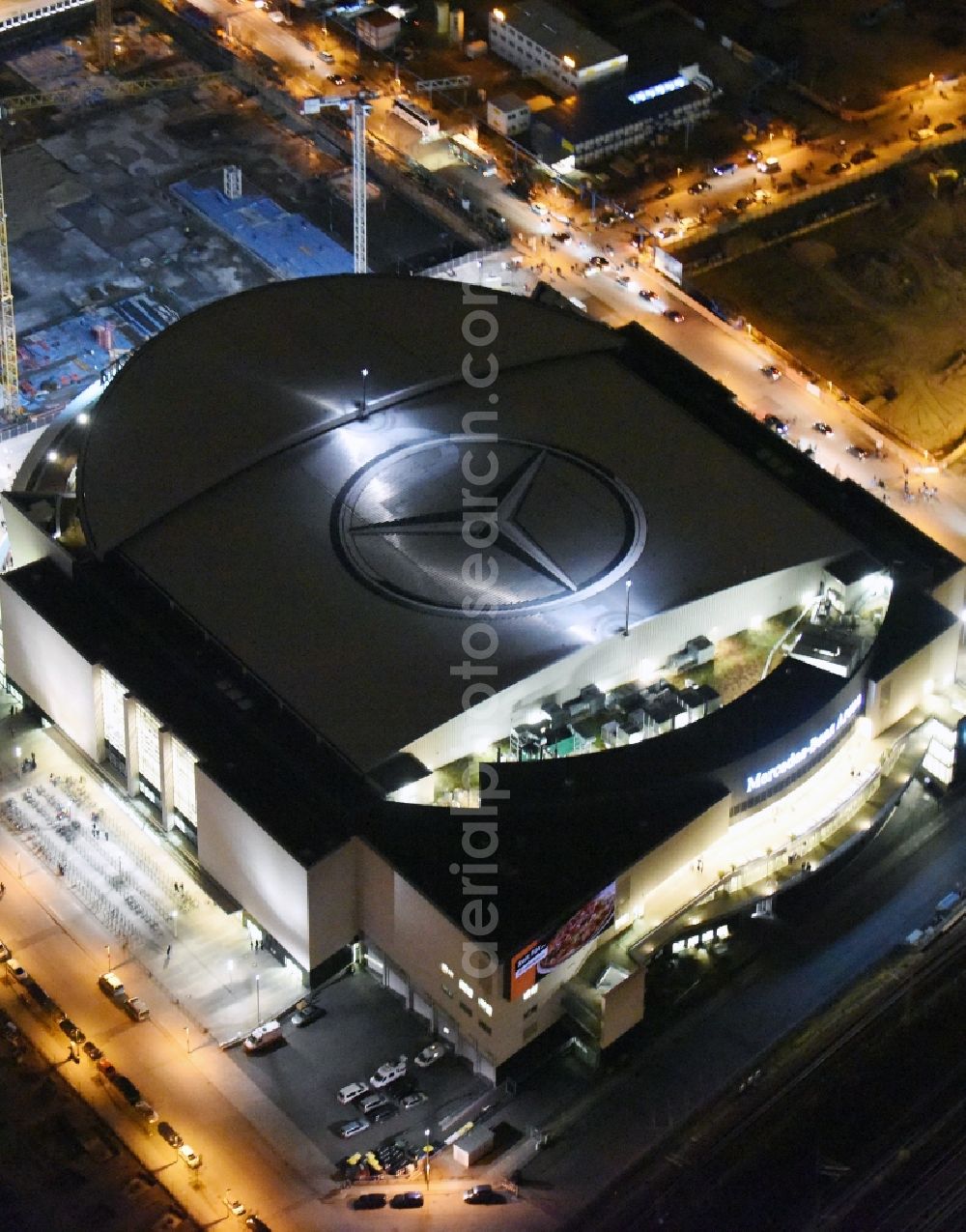 Berlin at night from above - Night view of Mercedes-Benz-Arena on the Spree riverbank in the Friedrichshain part of Berlin. The former O2 World - now Mercedes-Benz-Arena - is located in the Anschutz Areal, a business and office space on the riverbank